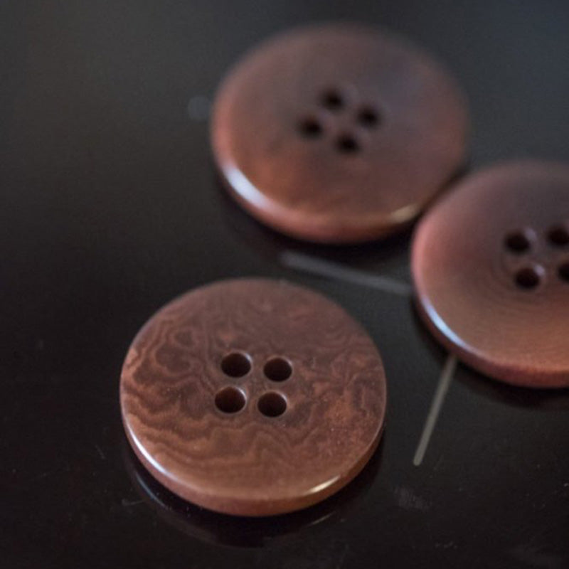 20mm corozo button with 4 holes. Corozo is a 100% natural product which is similar in consistency to a hard resin. It is made up of a very tightly wound organic fibers which give it excellent durability and scratch resistance. Sold individually.