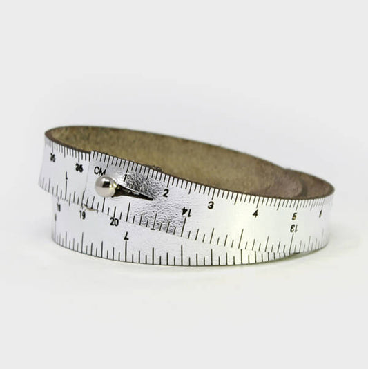 A silver leather wristband with engraved inch and centimeter measurements. If you find yourself always needing to measure things when you're on the go, this is perfect for you! Sizes are based on wrapping around your wrist twice. The stud closure is nickel-free, made from chrome-plated brass. Different sizes available.