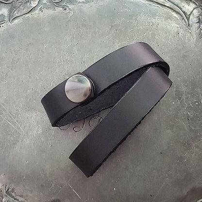 The Simple Snap Shawl Cuff is made from a hand-cut 13mm wide strip of supple, smooth leather. Available in five colours. The Simple Snap wraps twice around knitwear and closes with a snap. It can also be worn wrapped once as a leather choker necklace or wrapped twice as a bracelet.
