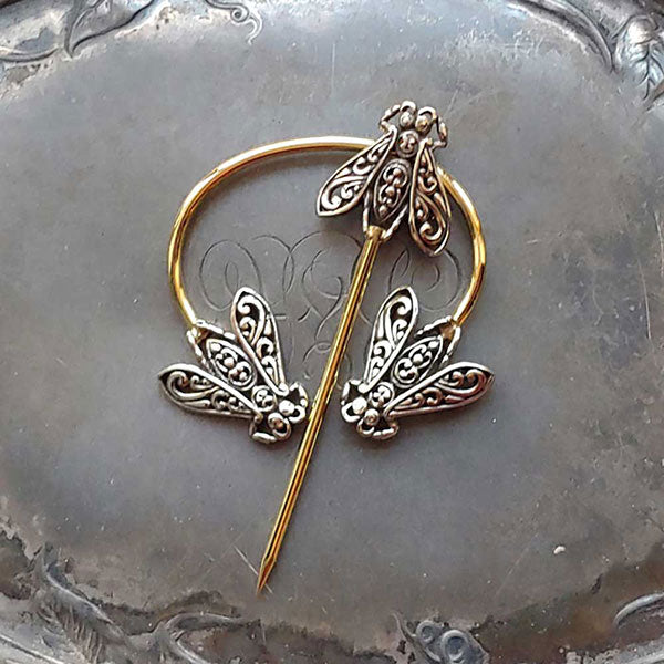 This gorgeous penannular brooch combines three filigree honeybees, evoking the ways honeybees cluster socially in their hives, celebrating the fundamental role pollinators play in the healthy maintenance of plant life and in our food supply. An elegant and secure shawl and garment closure. Hand-made Fair Trade.