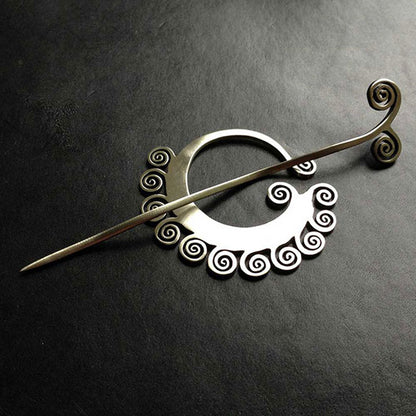 Coil Shawl Pin by JUL Designs. Available in white brass and blackened white brass. Elegant and sleek with a timeless design that is at once ancient and contemporary. The ripples in the stick ensure it will hold onto the knitwear, allowing it to nest comfortably in the ring it's designed to accompany. Hand-made Fair Trade