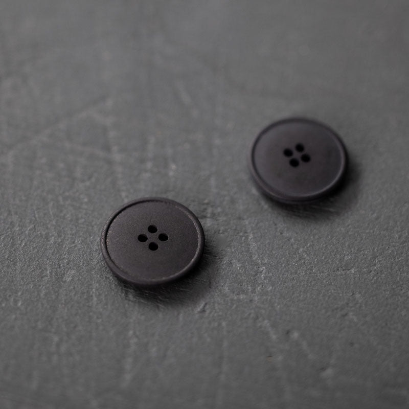 20mm hemp button with 4 holes. Beautiful matte and chalky finish. They are available in the following colours: Black, Brick, Painters Navy, Stanley Tan, Tobacco. Composition: 50-60% Recycled hemp fibres, 15-20% Fillers, 15-20% Technical binders or dyes. Fully washable. Sold individually. Made in Turkey. Depicted here in Black.