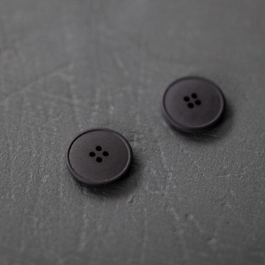20mm hemp button with 4 holes. Beautiful matte and chalky finish. They are available in the following colours: Black, Brick, Painters Navy, Stanley Tan, Tobacco. Composition: 50-60% Recycled hemp fibres, 15-20% Fillers, 15-20% Technical binders or dyes. Fully washable. Sold individually. Made in Turkey. Depicted here in Black.