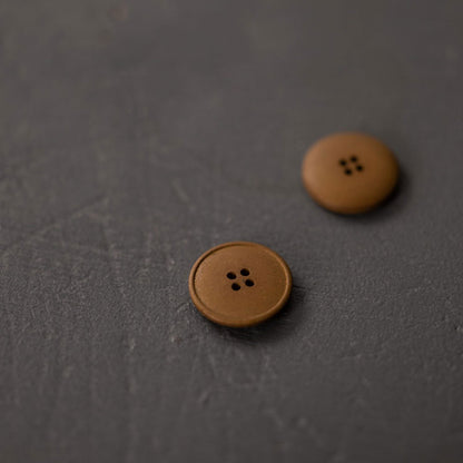 20mm hemp button with 4 holes. Beautiful matte and chalky finish. They are available in the following colours: Black, Brick, Painters Navy, Stanley Tan, Tobacco. Composition: 50-60% Recycled hemp fibres, 15-20% Fillers, 15-20% Technical binders or dyes. Fully washable. Sold individually. Made in Turkey. Depicted here in Stanley Tan.