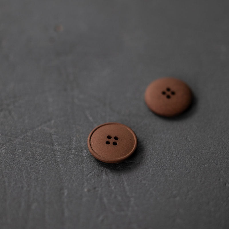 20mm hemp button with 4 holes. Beautiful matte and chalky finish. They are available in the following colours: Black, Brick, Painters Navy, Stanley Tan, Tobacco. Composition: 50-60% Recycled hemp fibres, 15-20% Fillers, 15-20% Technical binders or dyes. Fully washable. Sold individually. Made in Turkey. Depicted here in Tobacco.