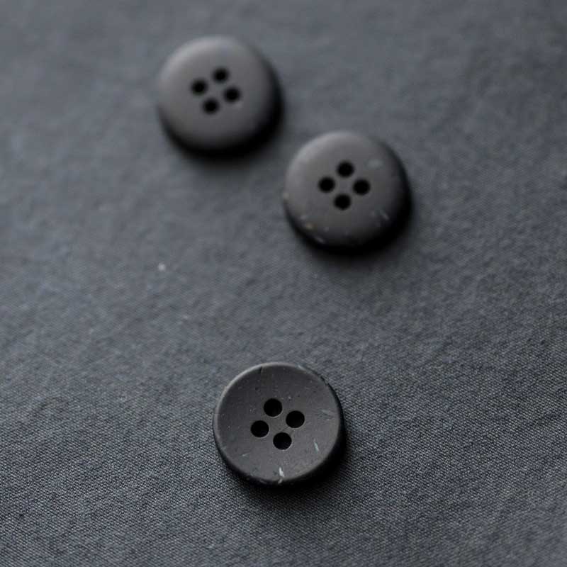 18mm recycled resin button with 4 holes. Available in the following colours: Brick, Ink and Olive. These buttons are made from 10% wooden wastage. Sold individually. Made in Italy. Depicted here in Ink.