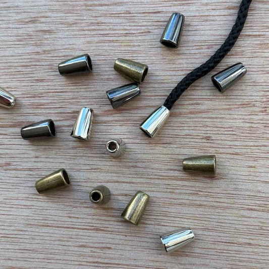 Metal cord end gives a neat and tidy look to drawstrings and knitted icord strings. Colours –  Nickel, Gunmetal or Antique Brass. Height: 14mm. Hole size: 3mm at the top. Priced per set of 2 pieces.